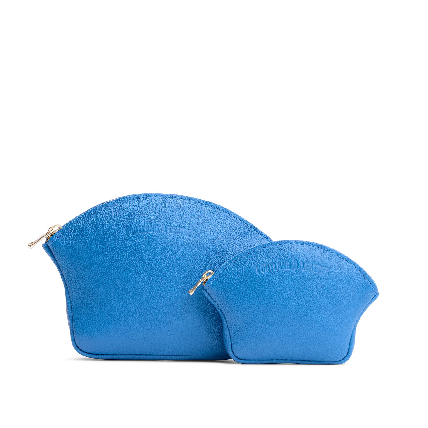 Skydive | Comparison shot of small and large seashell shaped leather makeup bags with curved top zipper and flat bottom