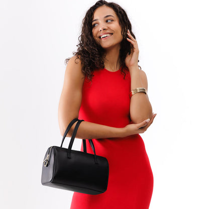 Black*Large | Model wearing mini duffle shaped handbag with crossbody strap
