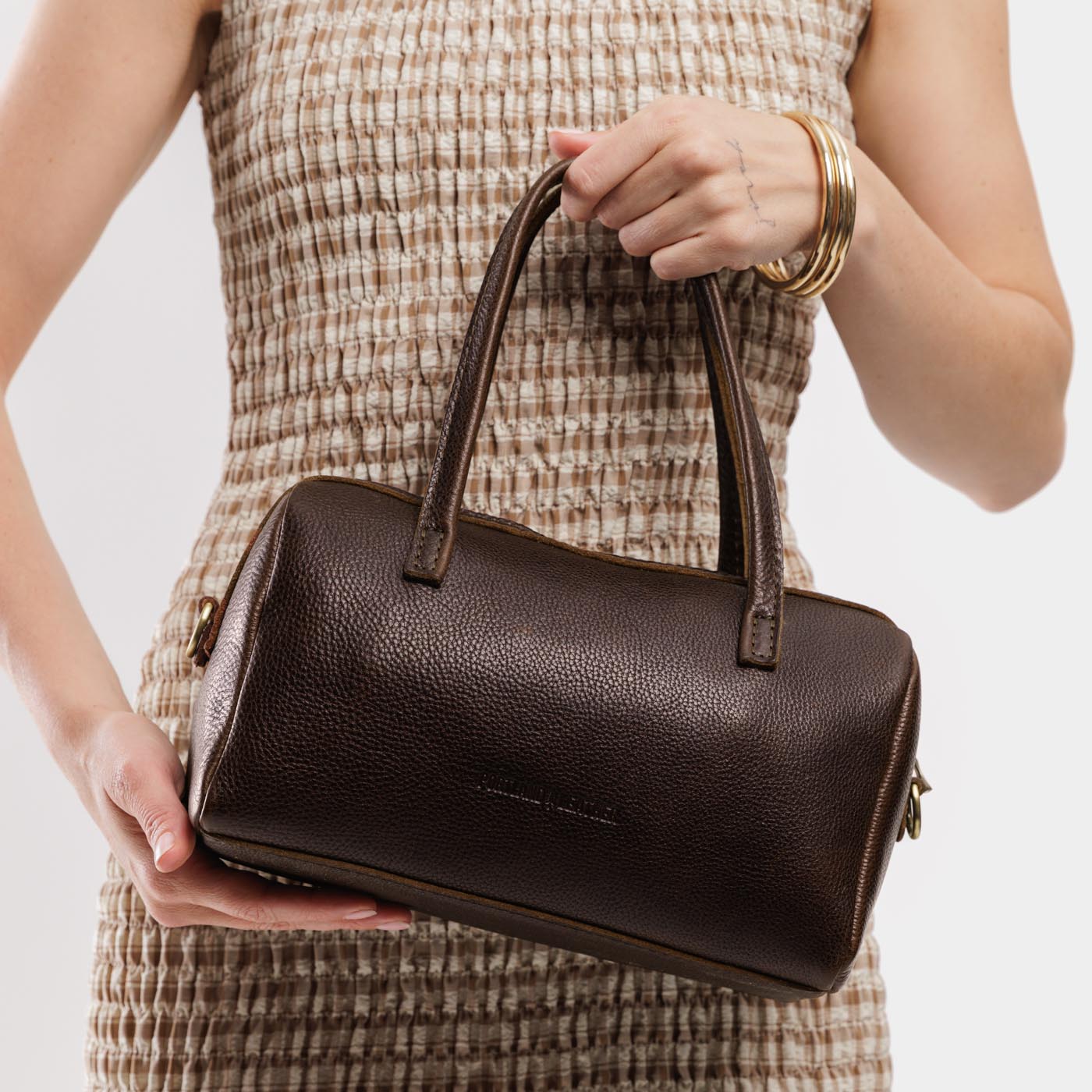 Coldbrew*Large | Model wearing mini duffle shaped handbag with crossbody strap