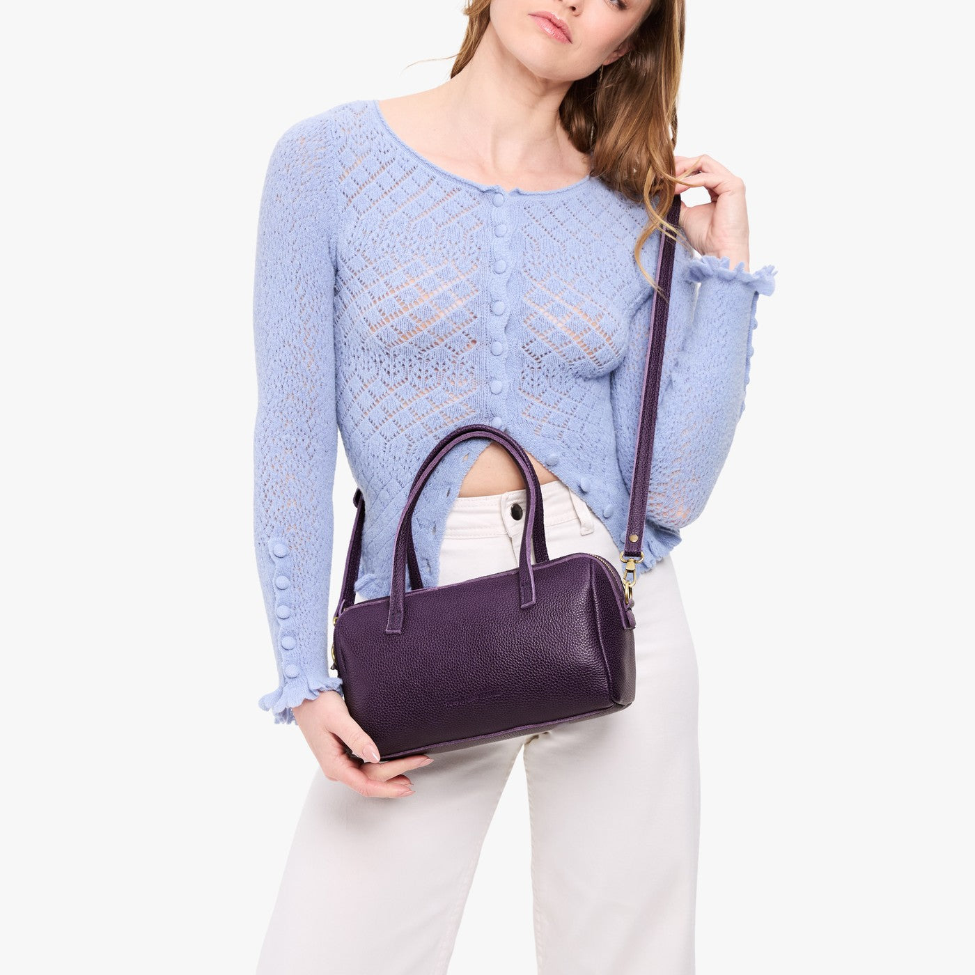 Empire*Large | Model holding mini duffle shaped handbag with crossbody strap