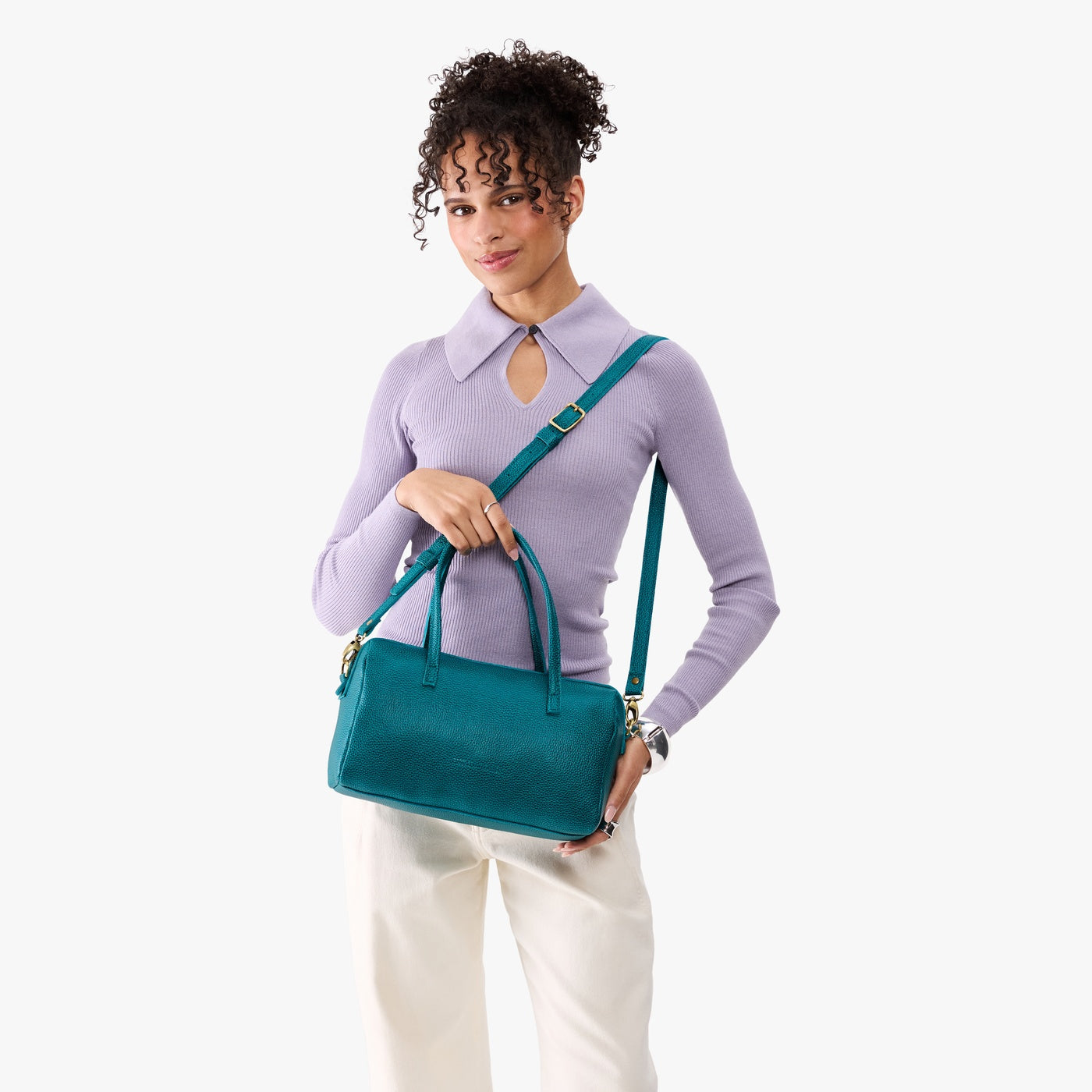 Aquarius*Oversized | Model holding mini duffle shaped handbag with crossbody strap