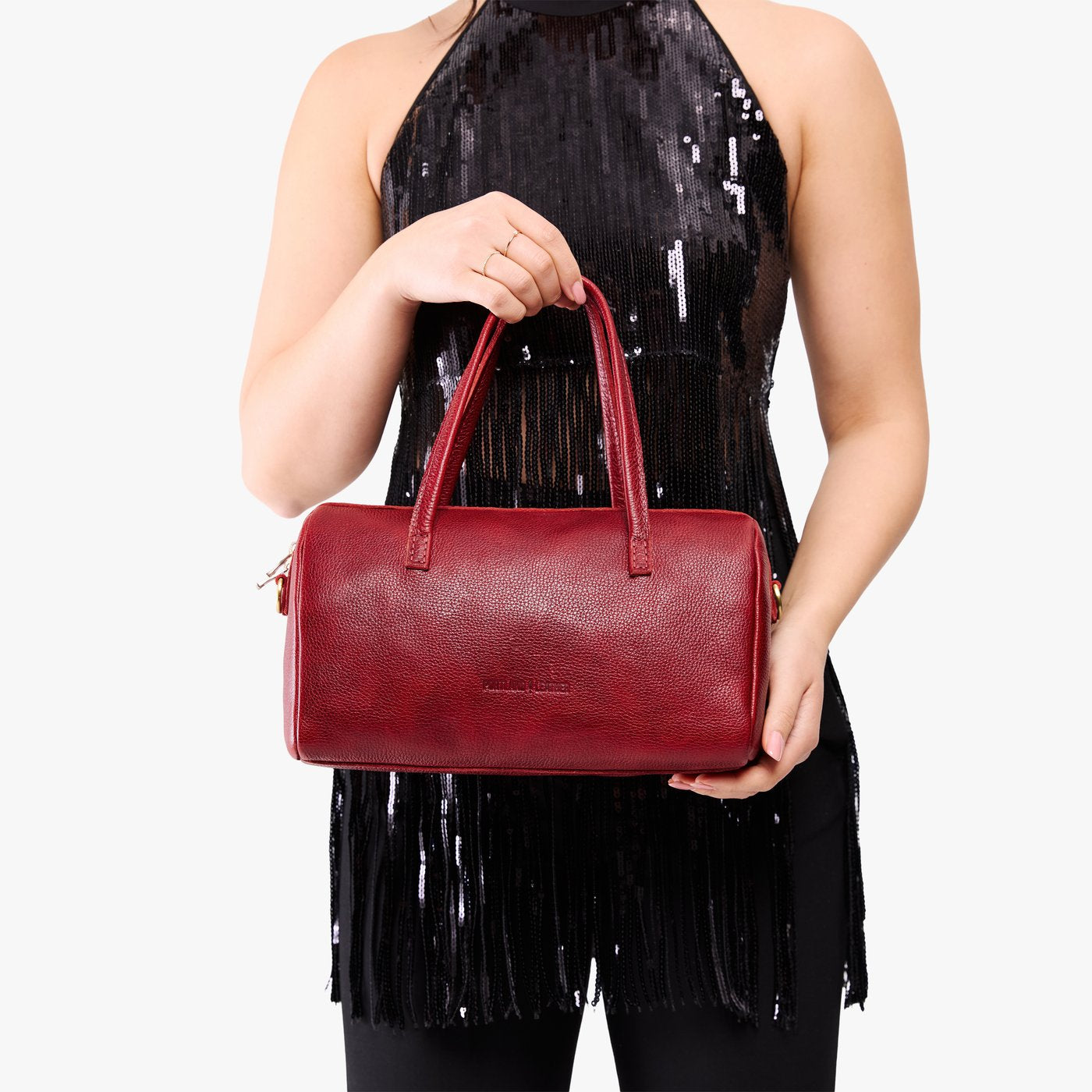 Chili Red*Oversized | Model holding mini duffle shaped handbag with crossbody strap