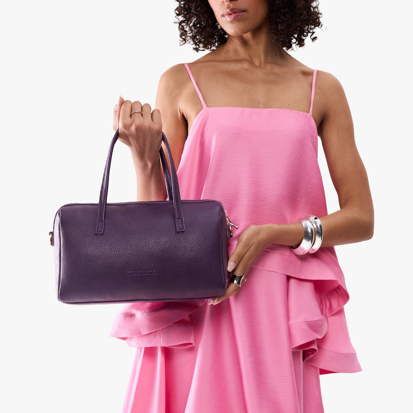 Empire*Oversized | Model holding mini duffle shaped handbag with crossbody strap