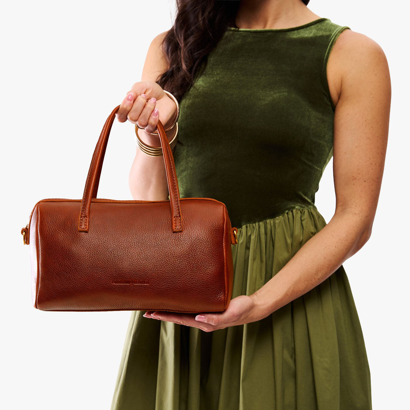 Nutmeg*Oversized | Model holding mini duffle shaped handbag with crossbody strap