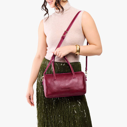 Orchid*Oversized | Model holding mini duffle shaped handbag with crossbody strap