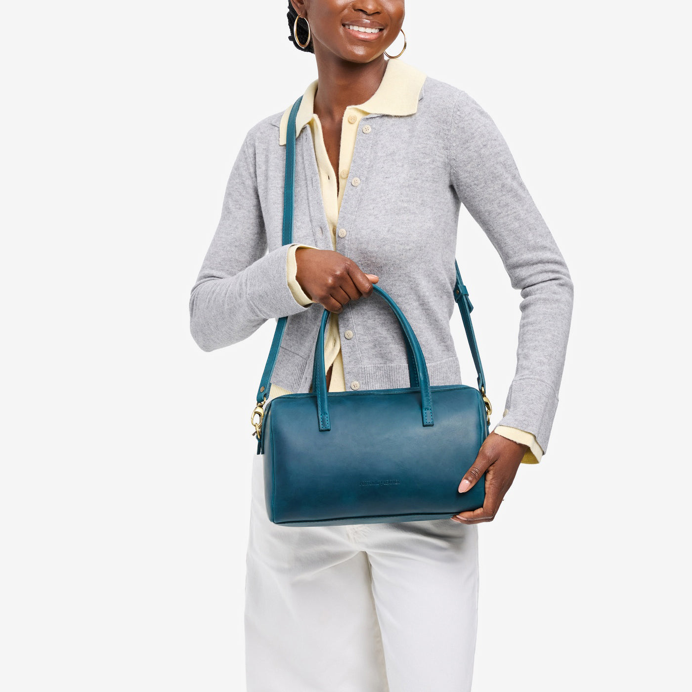 Westward Blue*Oversized | Model holding mini duffle shaped handbag with crossbody strap