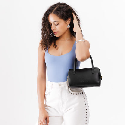 Black*Small | Model wearing mini duffle shaped handbag with crossbody strap
