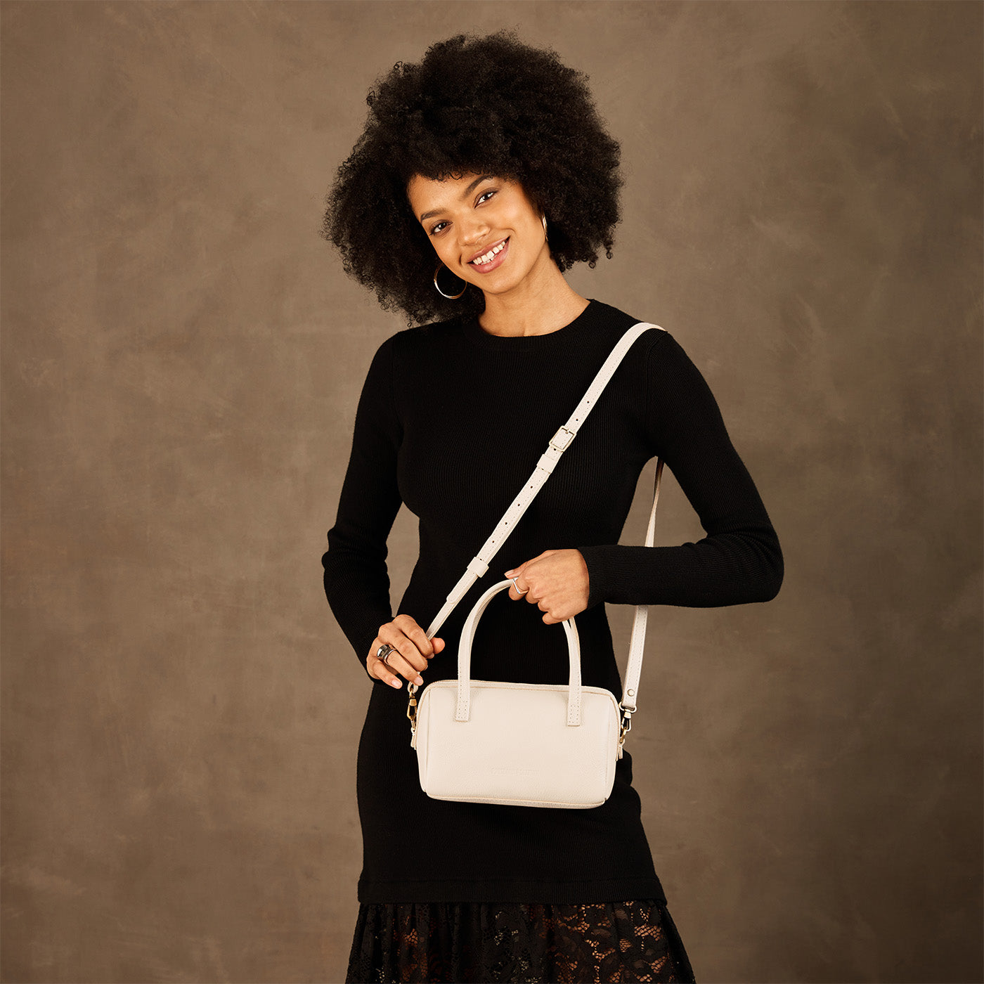 Pebbled Bone*Small | Model holding mini duffle shaped handbag with crossbody strap