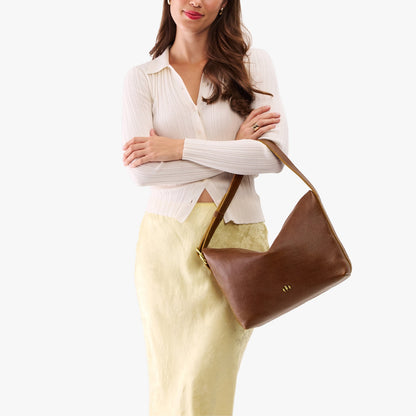 Asheville*Large | Model Wearing medium sized slouchy leather shoulder bag with zipper opening and three metal tree emblems