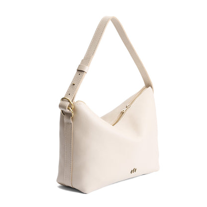 Pebbled Bone*Large | Model Wearing medium sized slouchy leather shoulder bag with zipper opening and three metal tree emblems