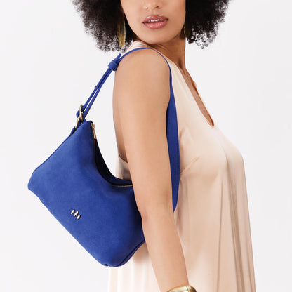 Joni Blue*Small | Model wearing petite slouchy leather shoulder bag with zipper opening and three metal tree emblems