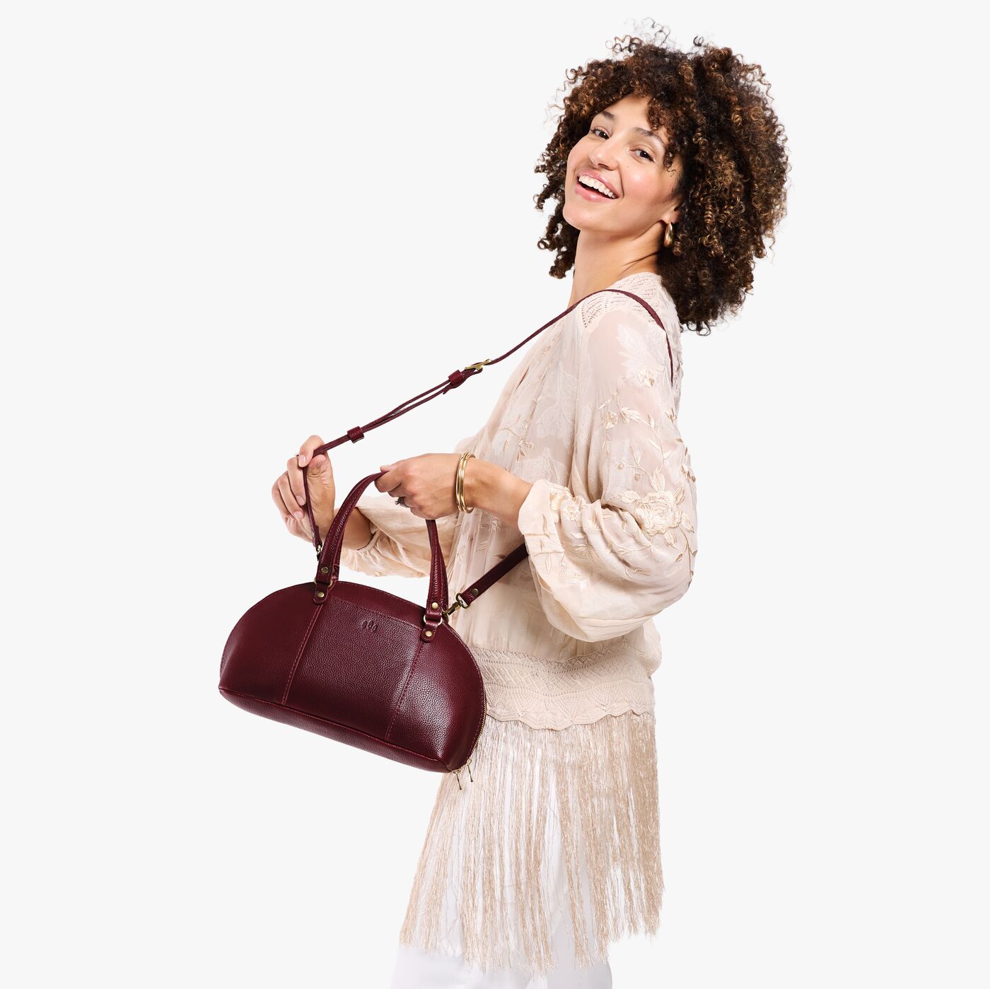 Cabernet*Small | Model holding a half circle crossbody bag with handles and removable crossbody strap
