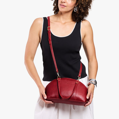 Chili Red*Small | Model holding a half circle crossbody bag with handles and removable crossbody strap