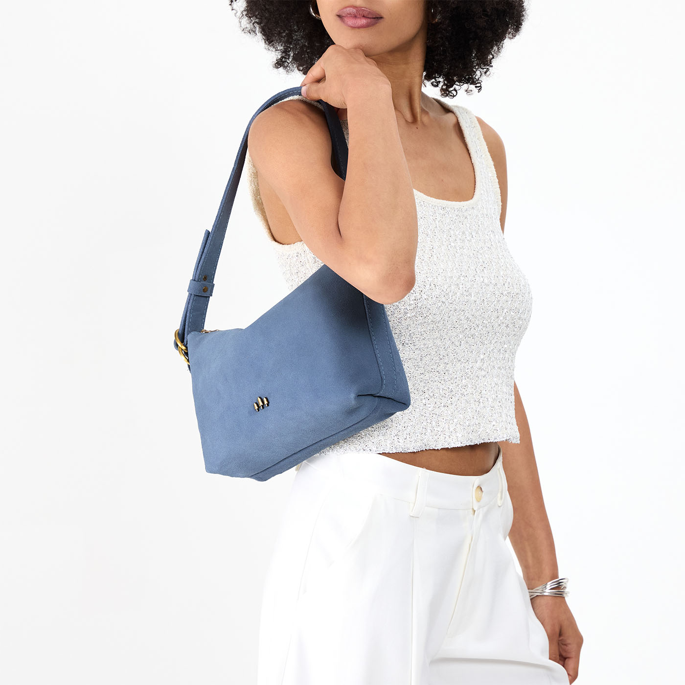Denim*Small | Model holding a Slouchy Shoulder Bag that has a zipper opening and three metal tree emblems
