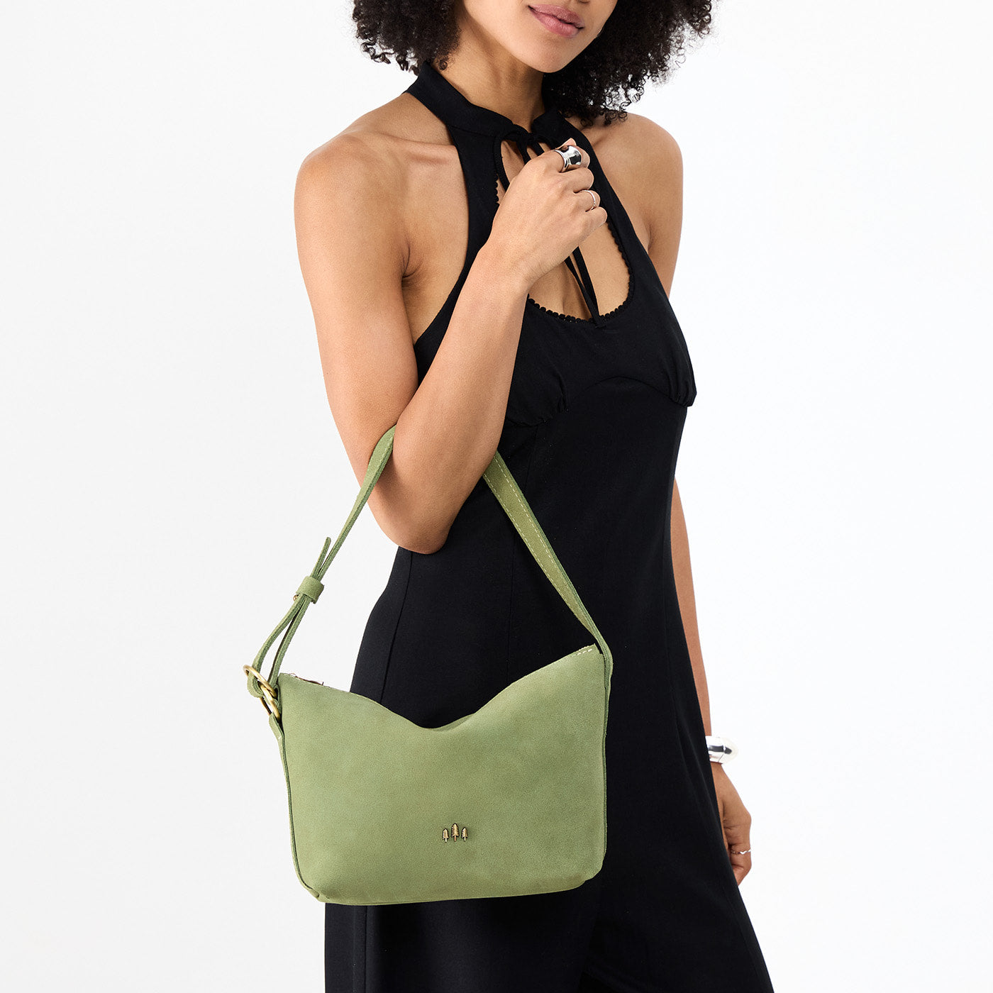Laurel*Small | Model holding a Slouchy Shoulder Bag that has a zipper opening and three metal tree emblems