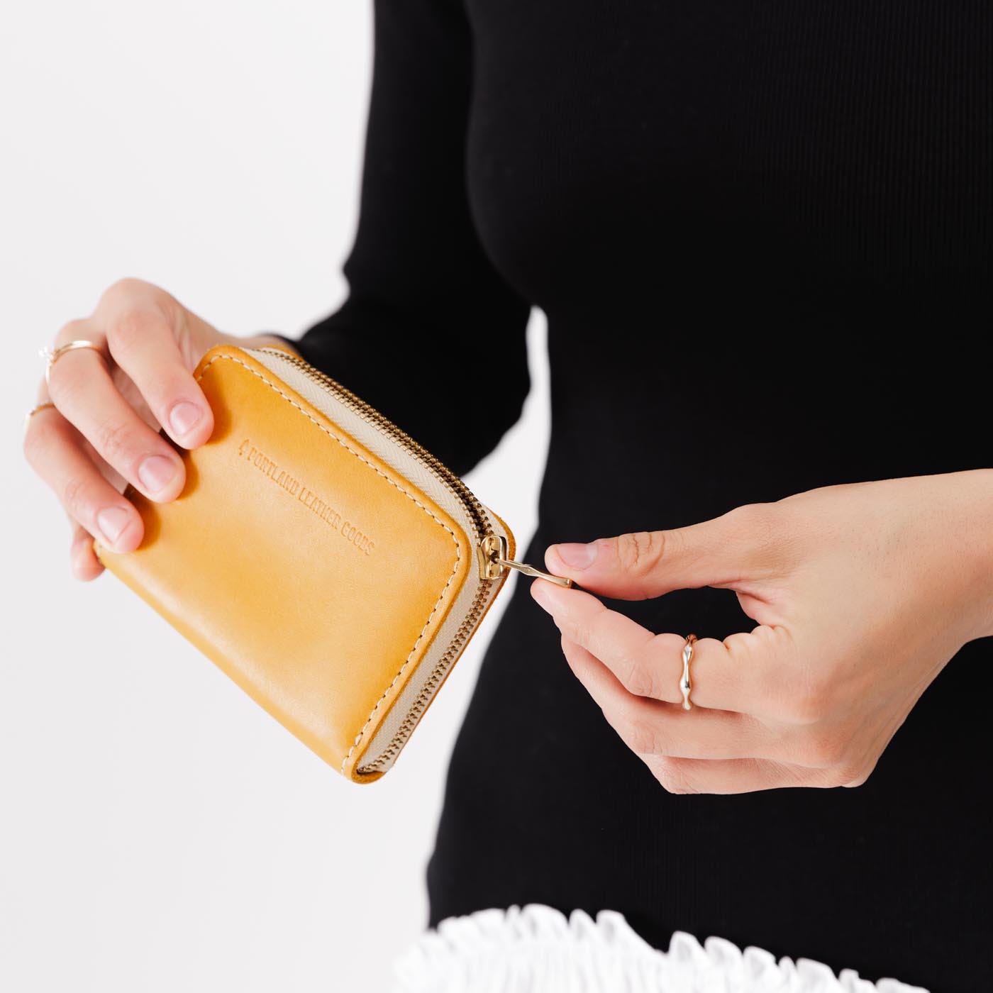 Sunflower | Model holding small leather wallet with zipper