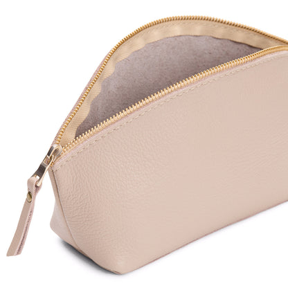 Oatmilk | Close-up of spacious leather makeup bag with curved seams and top zipper