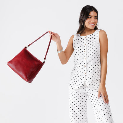 Chili Red*Small | Model holding triangular shoulder bag with antiqued brass finished hardware