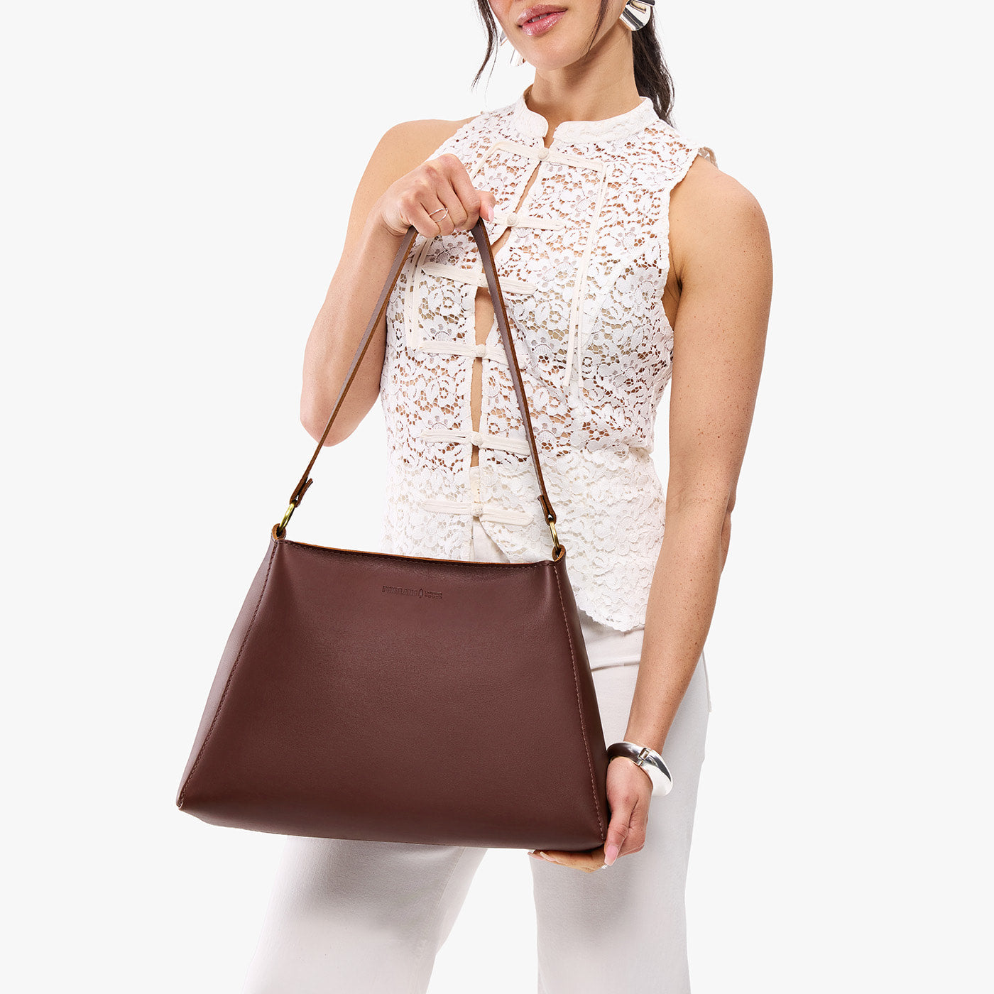 Cognac*Large | Model holding large triangular shoulder bag with antiqued brass finished hardware