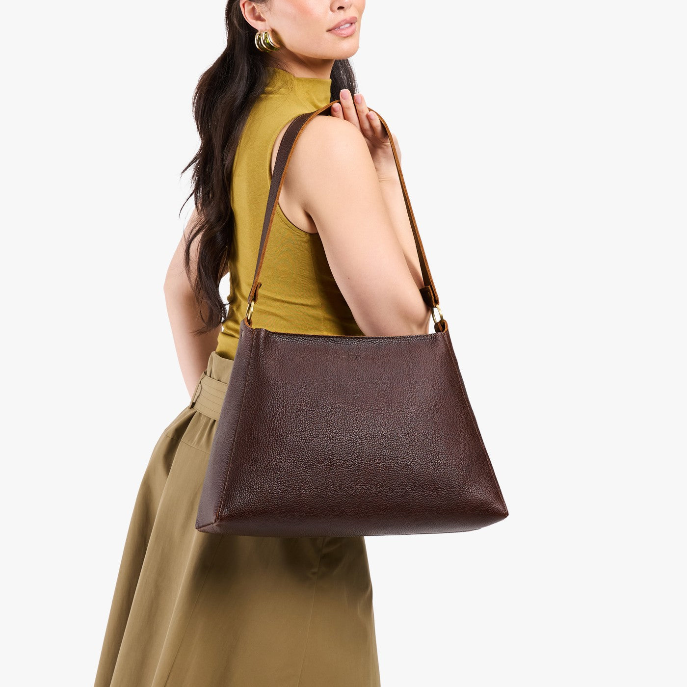 Coldbrew*Large | Model carrying large triangular shoulder bag with antiqued brass finished hardware