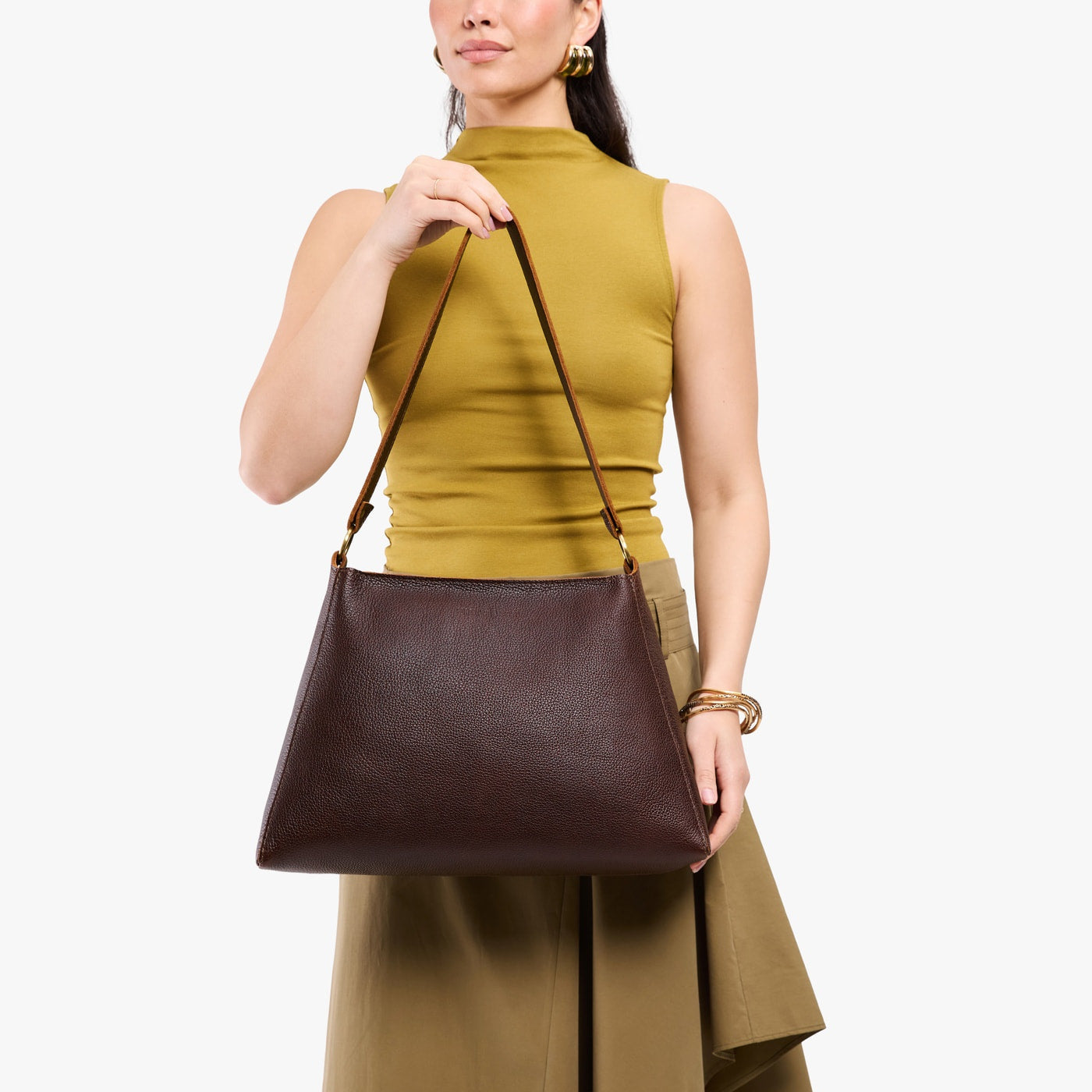 Coldbrew*Large | Model holding large triangular shoulder bag with antiqued brass finished hardware
