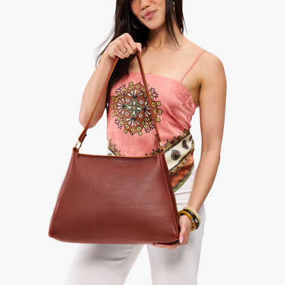 Nutmeg*Large | Model holding large triangular shoulder bag with antiqued brass finished hardware