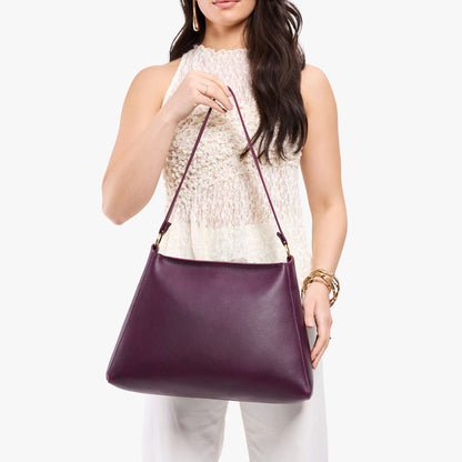 Plum*Large | Model holding large triangular shoulder bag with antiqued brass finished hardware