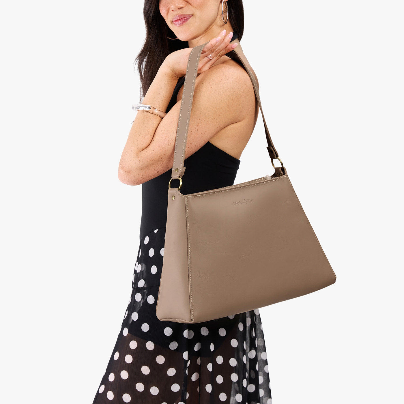 Stone*Large | Model carrying large triangular shoulder bag with antiqued brass finished hardware