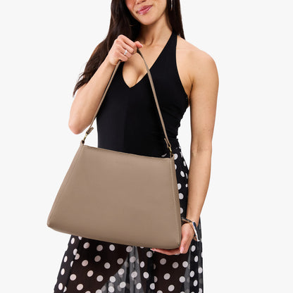 Stone*Large | Model holding large triangular shoulder bag with antiqued brass finished hardware