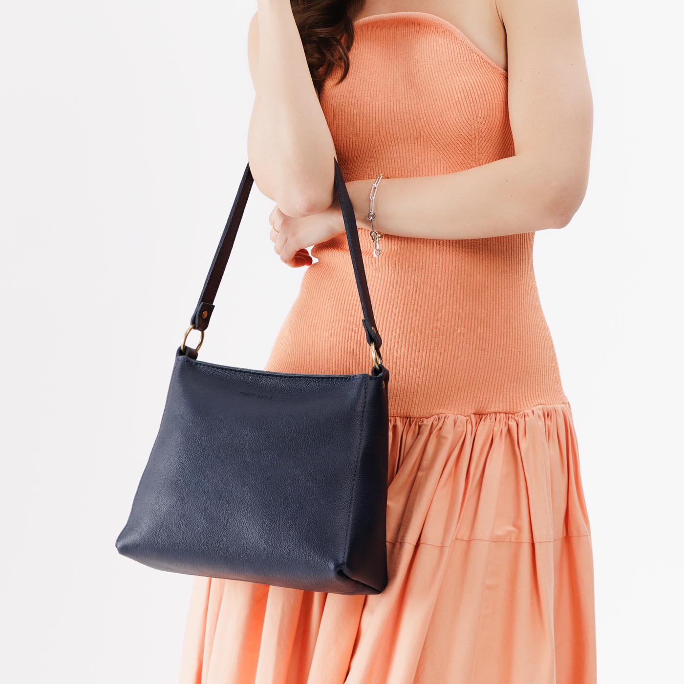 Night Owl*Small | Model wearing triangular shoulder bag with antiqued brass finished hardware