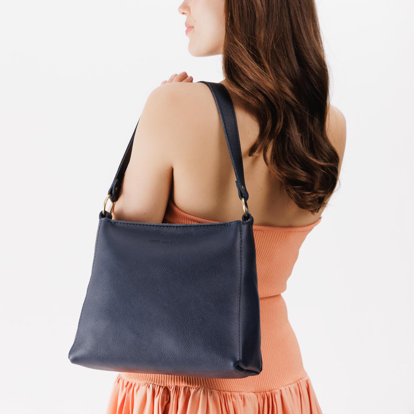Night Owl*Small | Model wearing triangular shoulder bag with antiqued brass finished hardware