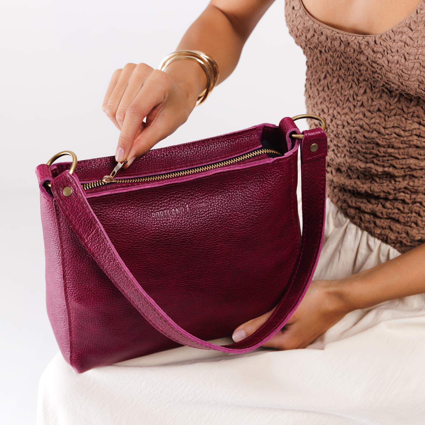 Orchid*Small | Model holding triangular shoulder bag with antiqued brass finished hardware