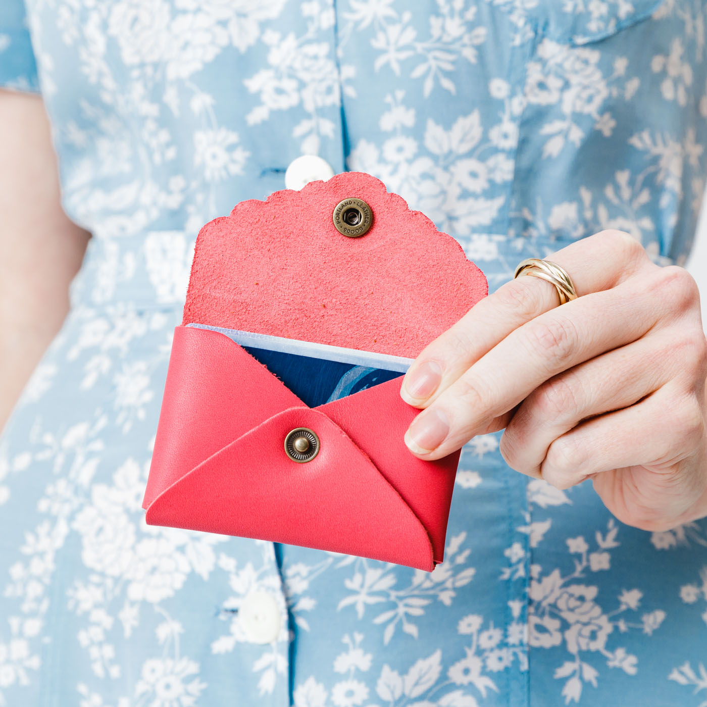 Tulip | Model holding small leather wallet with scalloped edge open