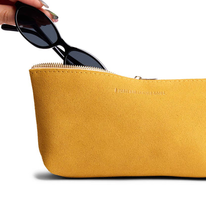 Dijon | Model hand pulling pair of sunglasses from leather utility bag pouch with top zipper