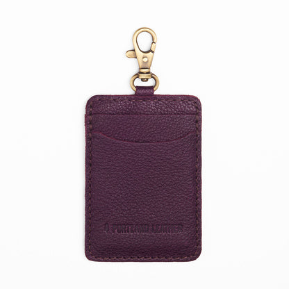 Plum | A leather card holder with a swivel lobster clasp on a white background