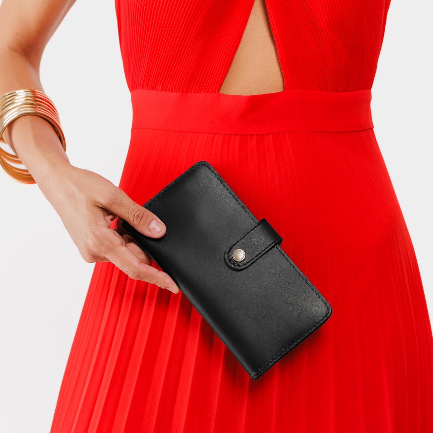 Black | Model holding leather wallet with snap closed