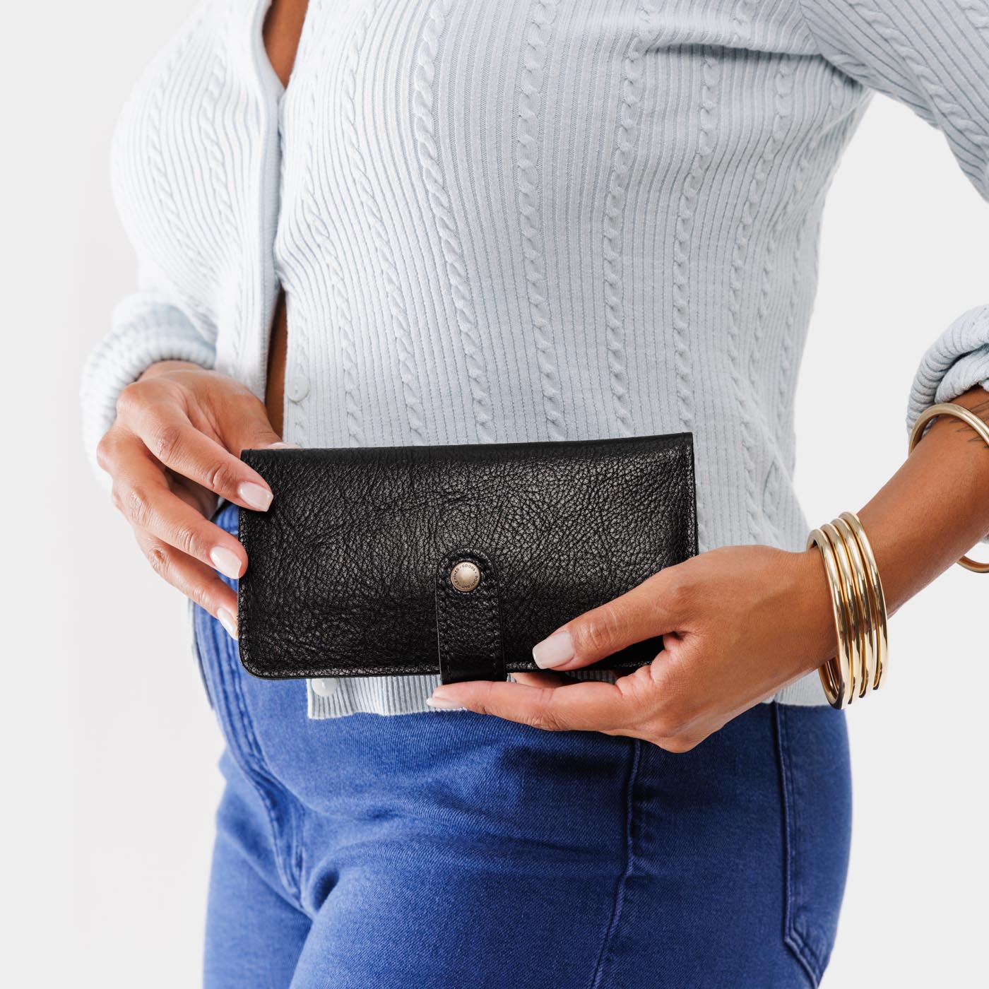 Pebbled--black | Model holding leather wallet with snap closed
