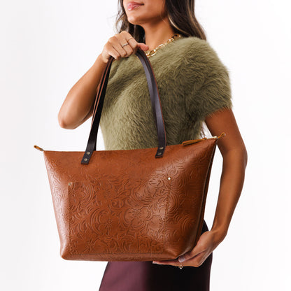 Meadow*Zipper | Model holding large zipper leather tote bag with sturdy bridle handles and front pocket