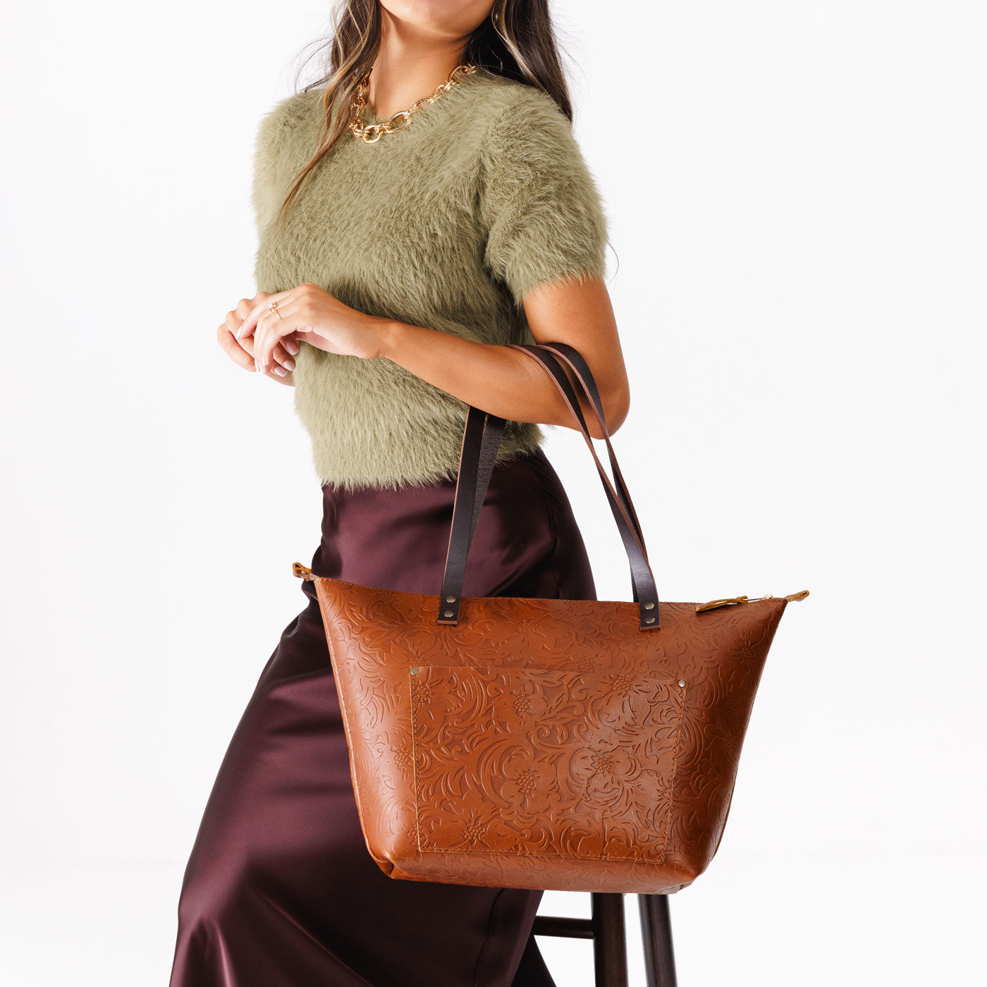 Meadow*Zipper | Model holding large zipper leather tote bag with sturdy bridle handles and front pocket